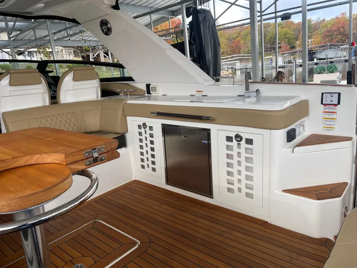  Yacht Photos Pics 2022 Sea Ray 400 SLX interior with kitchenette and seating, featuring wood accents and modern design.
