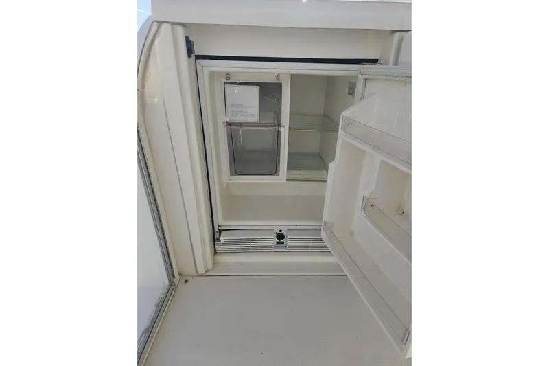 Long Time Comin' Yacht Photos Pics Open refrigerator on 2000 Cruisers Yachts 4450 Express Motoryacht, showing interior shelves.