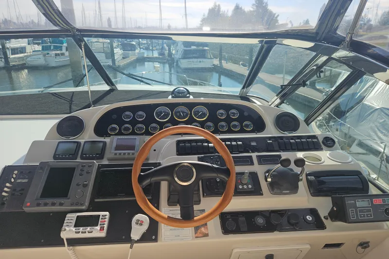 Long Time Comin' Yacht Photos Pics Cockpit of 2000 Cruisers Yachts 4450 Express Motoryacht with steering wheel and control panels.