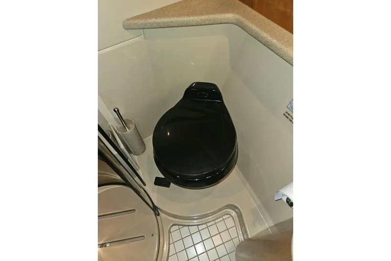 Long Time Comin' Yacht Photos Pics Bathroom in 2000 Cruisers Yachts 4450 Express Motoryacht, featuring a sleek black toilet.