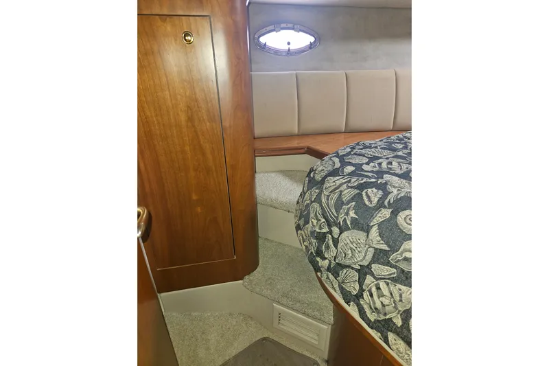 Long Time Comin' Yacht Photos Pics Interior of 2000 Cruisers Yachts 4450 Express Motoryacht with wooden cabinetry and patterned bedding.