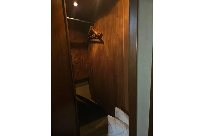 Long Time Comin' Yacht Photos Pics Wooden closet interior on 2000 Cruisers Yachts 4450 Express Motoryacht with hangers and pillows.