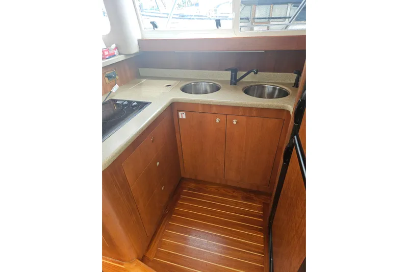 Long Time Comin' Yacht Photos Pics 2000 Cruisers Yachts 4450 Express Motoryacht kitchen with dual sinks and wooden cabinetry.
