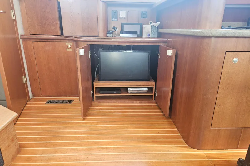 Long Time Comin' Yacht Photos Pics Interior of 2000 Cruisers Yachts 4450 Express Motoryacht with open wooden cabinet.