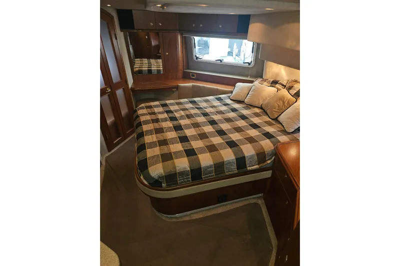 Long Time Comin' Yacht Photos Pics Luxurious bedroom interior of 2000 Cruisers Yachts 4450 Express Motoryacht with plaid bedding.