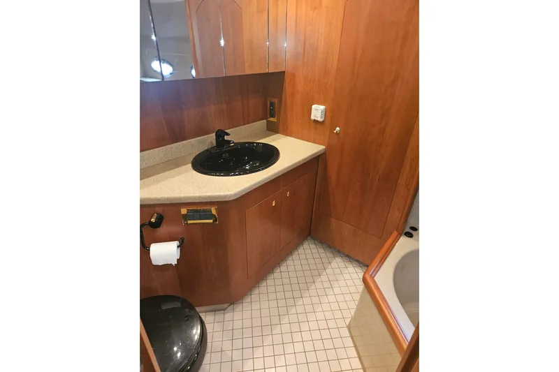 Long Time Comin' Yacht Photos Pics Luxurious bathroom in 2000 Cruisers Yachts 4450 Express Motoryacht with wood cabinetry and modern fixtures.