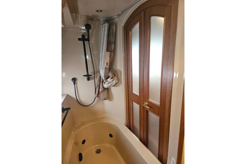 Long Time Comin' Yacht Photos Pics Luxurious bathroom in 2000 Cruisers Yachts 4450 Express Motoryacht with shower and wooden doors.