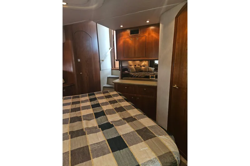 Long Time Comin' Yacht Photos Pics Luxurious interior of 2000 Cruisers Yachts 4450 Express Motoryacht with wood finish and cozy bedding.