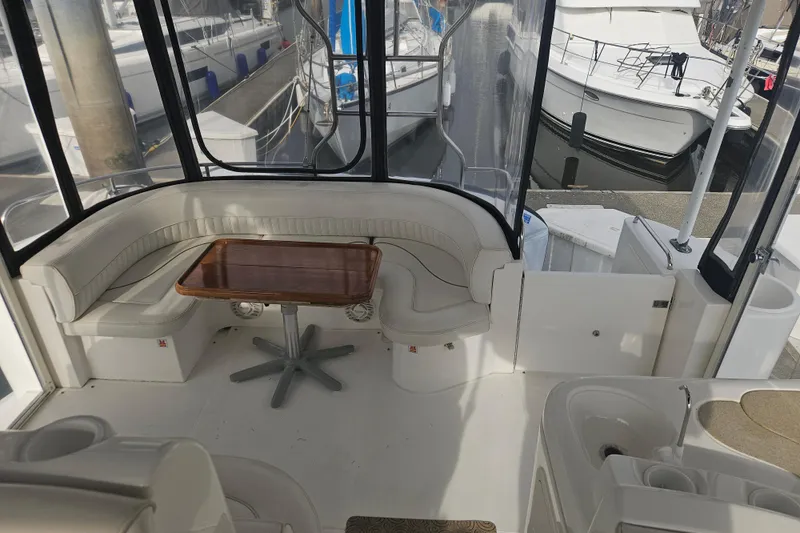 Long Time Comin' Yacht Photos Pics 2000 Cruisers Yachts 4450 Express Motoryacht interior with seating and table, docked at marina.
