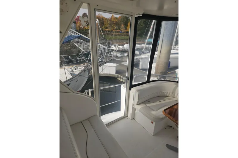 Long Time Comin' Yacht Photos Pics Interior view of 2000 Cruisers Yachts 4450 Express Motoryacht with seating and marina backdrop.