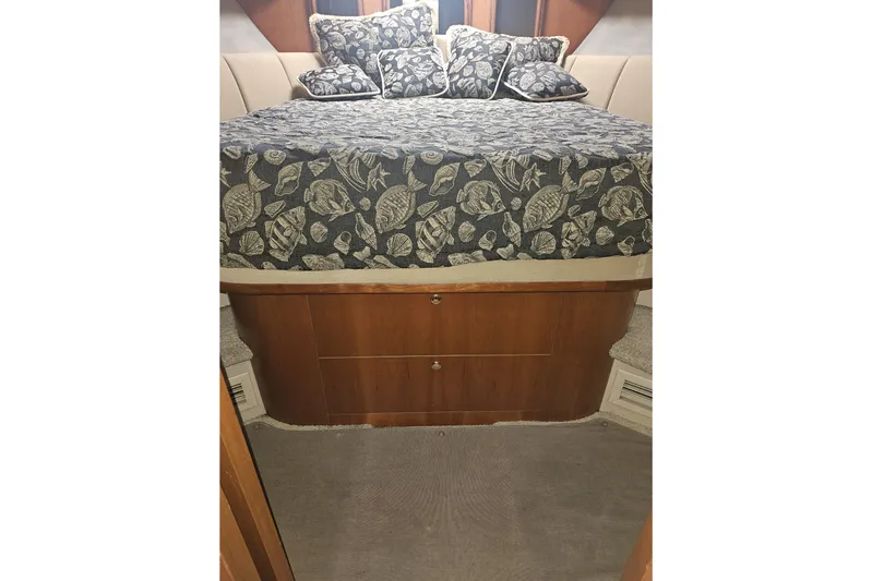 Long Time Comin' Yacht Photos Pics Interior of 2000 Cruisers Yachts 4450 Express Motoryacht with patterned bedding and wooden storage.