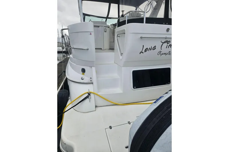 Long Time Comin' Yacht Photos Pics 2000 Cruisers Yachts 4450 Express Motoryacht docked, rear view with steps and cables.