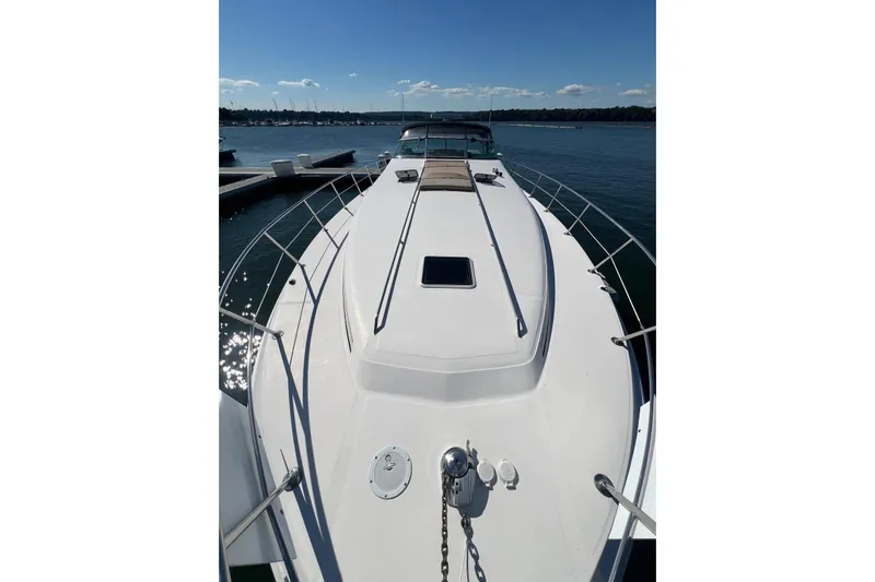 Abeona Yacht Photos Pics 1997 Sea Ray 500 Sundancer yacht on calm water, sunny day, marina in background.