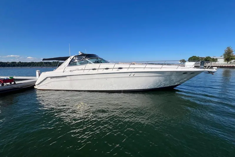 Abeona Yacht Photos Pics 1997 Sea Ray 500 Sundancer yacht docked on calm water under clear blue sky.