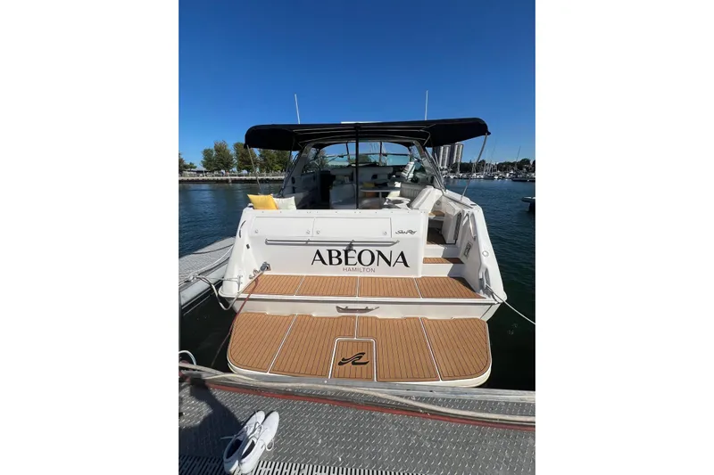 Abeona Yacht Photos Pics 1997 Sea Ray 500 Sundancer docked, rear view with teak deck and canopy.