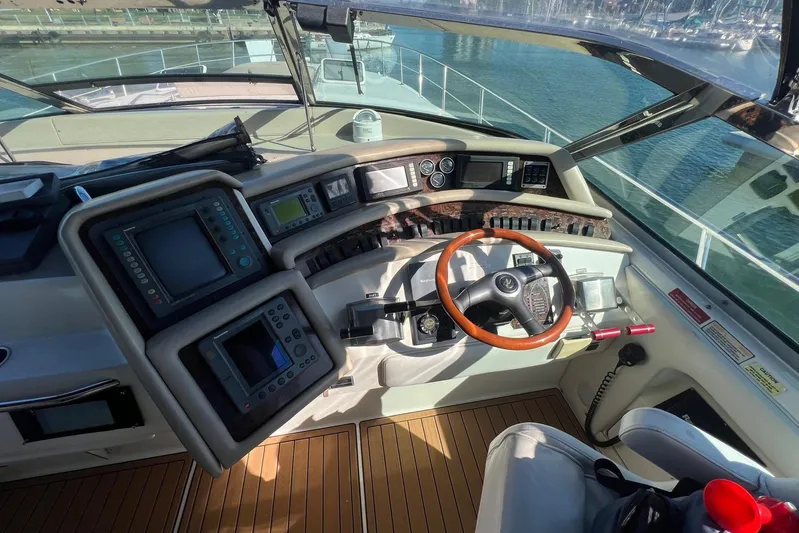 Abeona Yacht Photos Pics Cockpit of 1997 Sea Ray 500 Sundancer yacht with navigation instruments and wooden steering wheel.
