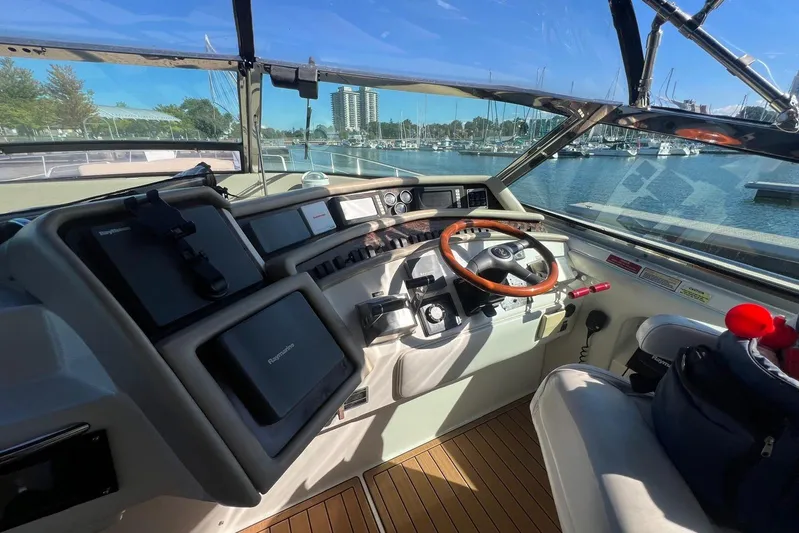 Abeona Yacht Photos Pics 1997 Sea Ray 500 Sundancer helm with wooden steering wheel and navigation equipment.