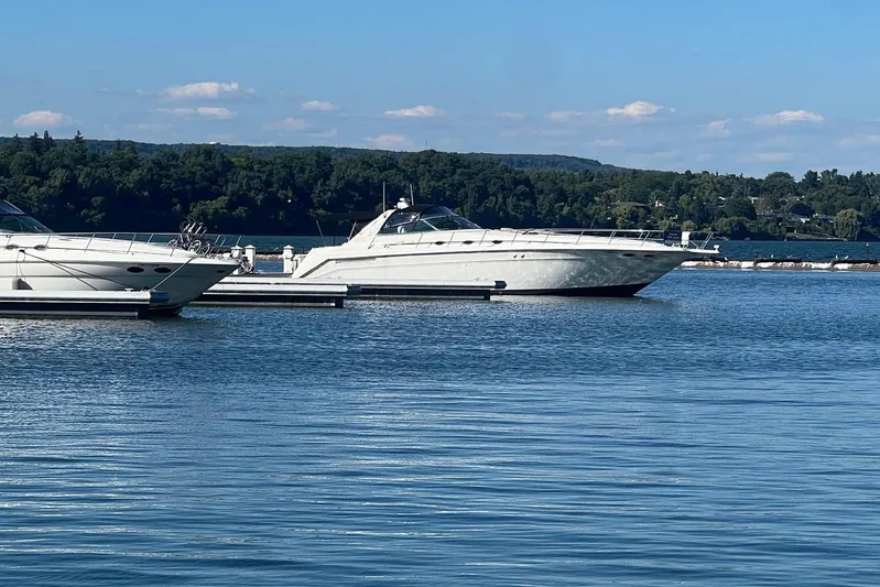 Abeona Yacht Photos Pics 1997 Sea Ray 500 Sundancer yacht docked on a serene lake with forested background.