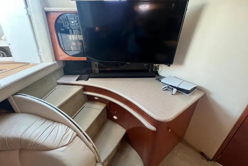 Abeona Yacht Photos Pics Interior of 1997 Sea Ray 500 Sundancer with TV and gaming console on counter.