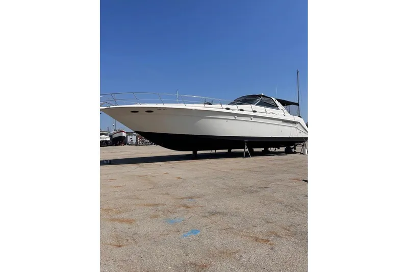 Abeona Yacht Photos Pics 1997 Sea Ray 500 Sundancer yacht on dry dock under clear blue sky.