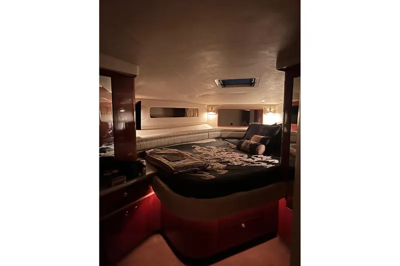 Abeona Yacht Photos Pics Luxurious cabin interior of 1997 Sea Ray 500 Sundancer yacht, featuring elegant bedding and ambient lighting.