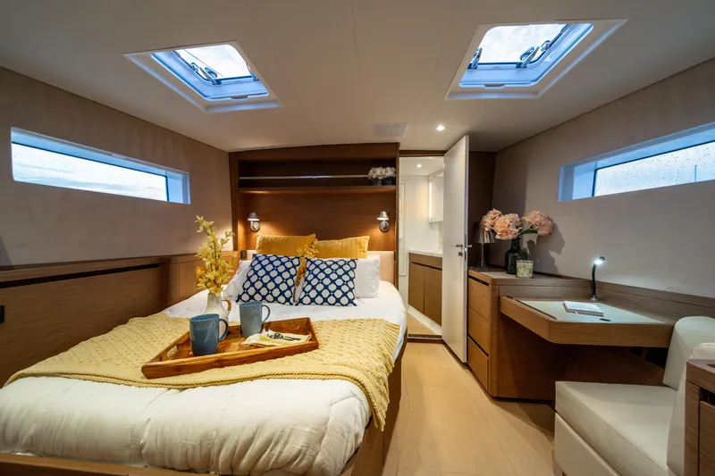 Fortitude Yacht Photos Pics Luxurious CNB 66 yacht bedroom interior, 2021 model, featuring cozy bed and elegant decor.