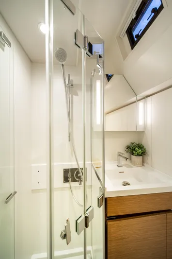 Fortitude Yacht Photos Pics Modern yacht bathroom with glass shower, sleek fixtures, and wooden cabinetry, CNB 66, 2021 model.
