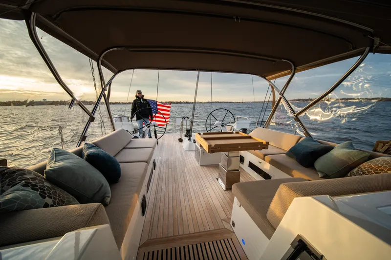 Fortitude Yacht Photos Pics Luxurious 2021 CNB 66 yacht interior with elegant seating, sailing at sunset.