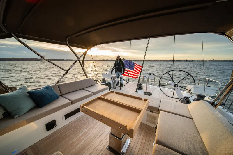 Fortitude Yacht Photos Pics Luxurious CNB 66 yacht interior with American flag, 2021 model, sailing at sunset.