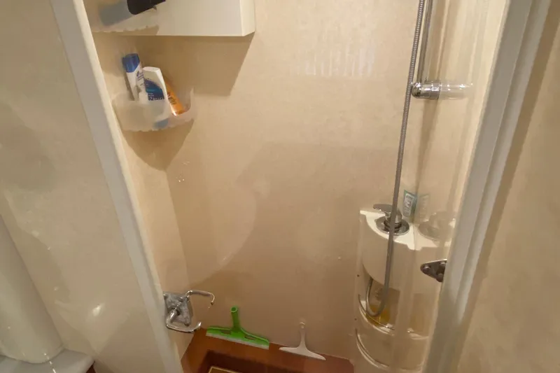 M/y "catherine" Yacht Photos Pics Compact shower area in a 2002 Ferretti Yachts 680, featuring toiletries and cleaning tools.