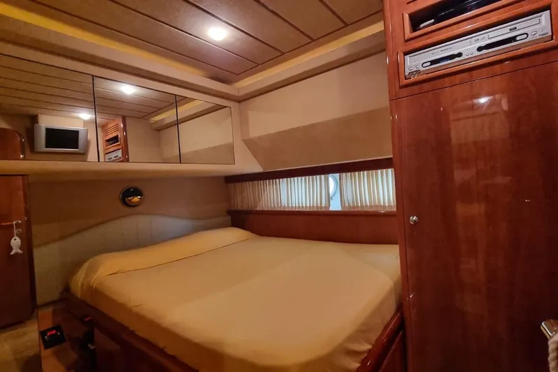M/y "catherine" Yacht Photos Pics Luxurious cabin interior of 2002 Ferretti Yachts 680 with wood paneling and cozy bed.