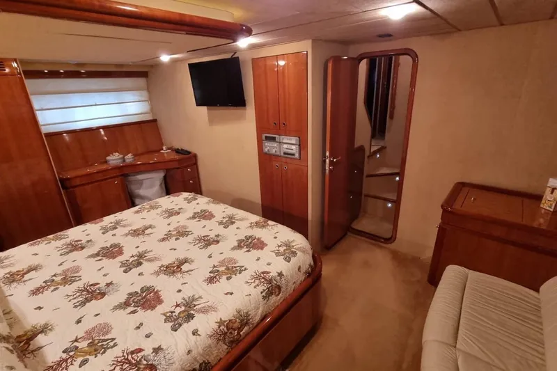 M/y "catherine" Yacht Photos Pics Luxurious bedroom interior of 2002 Ferretti Yachts 680 with elegant wood finishes.