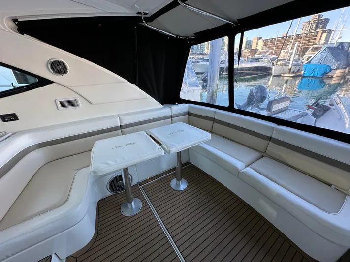  Yacht Photos Pics Interior of 2012 Sea Ray 470 Sundancer yacht with seating and tables, docked at marina.