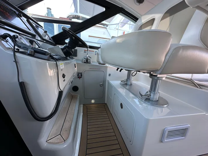  Yacht Photos Pics Interior helm of 2012 Sea Ray 470 Sundancer with white seating and wooden flooring.