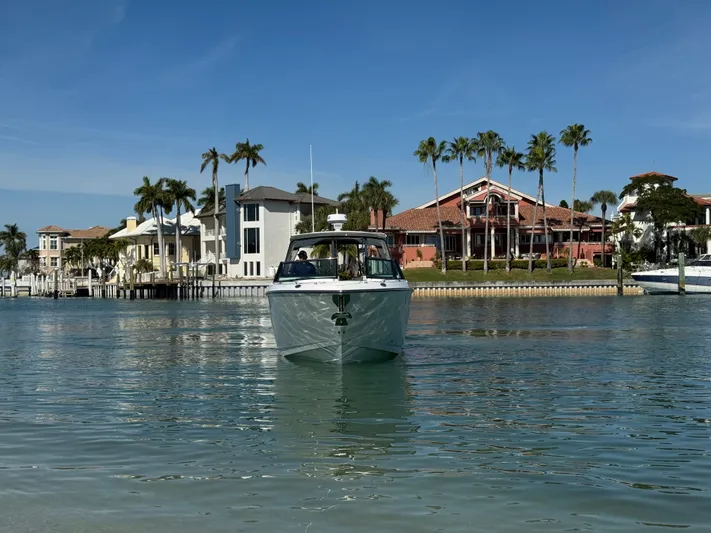 Inception Yacht Photos Pics 2023 Monterey 385 SS boat near coastal homes and palm trees.