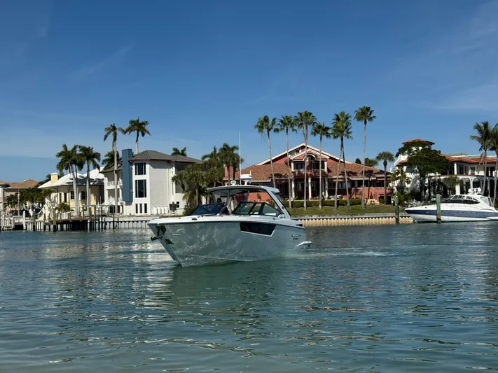 Inception Yacht Photos Pics Monterey 385 SS 2023 boat in front of luxury villas and palm trees.