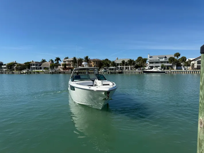 Inception Yacht Photos Pics 2023 Monterey 385 SS boat on calm water near coastal homes.