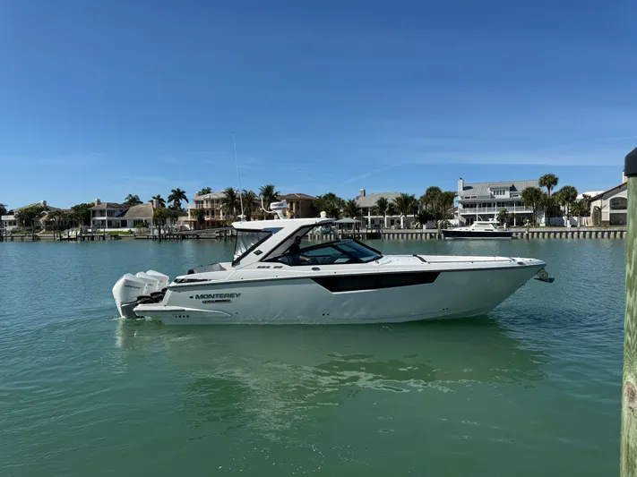 Inception Yacht Photos Pics 2023 Monterey 385 SS boat on calm water near coastal homes.