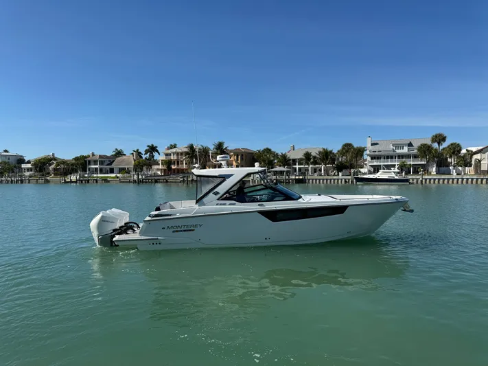 Inception Yacht Photos Pics 2023 Monterey 385 SS boat on calm water near coastal homes.