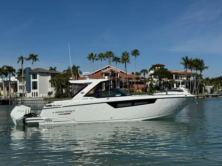 Inception Yacht Photos Pics 2023 Monterey 385 SS boat on calm water near luxury villas.
