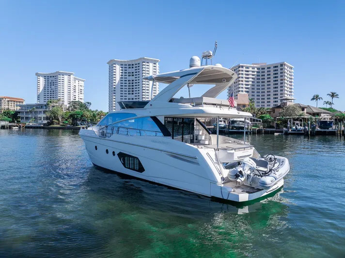 Holy Moly Yacht Photos Pics Luxury Absolute 50 Fly yacht, 2020 model, docked near waterfront buildings.