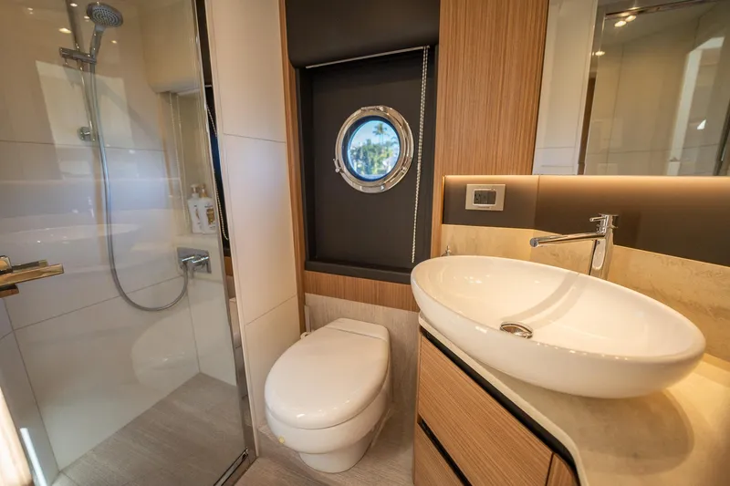 Holy Moly Yacht Photos Pics Luxurious bathroom in 2020 Absolute 50 Fly yacht with modern fixtures and porthole window.