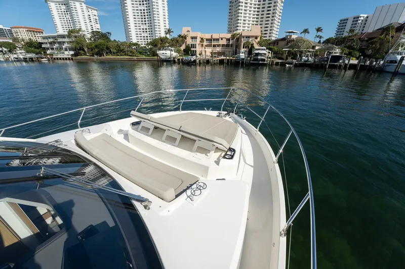 Holy Moly Yacht Photos Pics 2020 Absolute 50 Fly yacht with sunbathing area, docked near waterfront buildings.