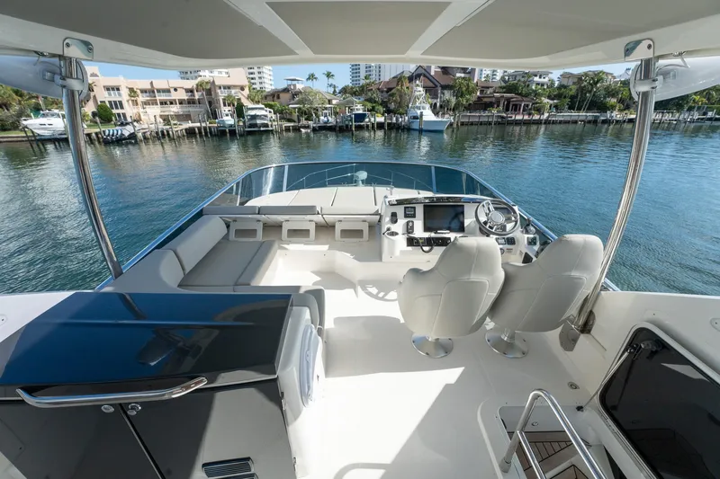 Holy Moly Yacht Photos Pics Flybridge of 2020 Absolute 50 Fly yacht with modern seating and controls, overlooking marina.