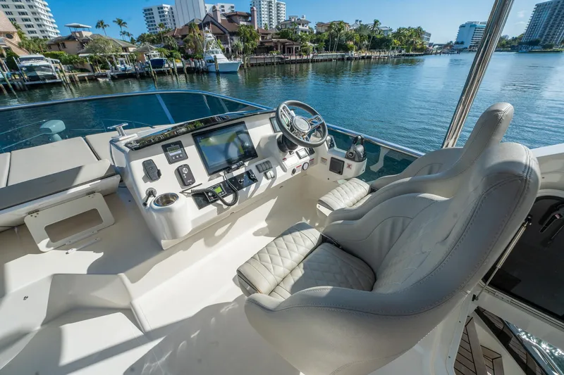 Holy Moly Yacht Photos Pics Flybridge helm of 2020 Absolute 50 Fly yacht with luxurious seating and waterfront view.