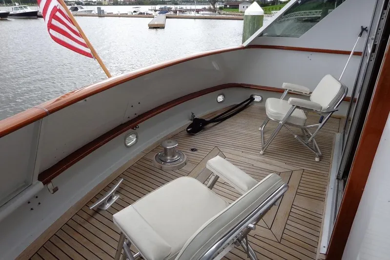  Yacht Photos Pics 1988 Burger 80 Motor Yacht deck with chairs and American flag, docked by the water.