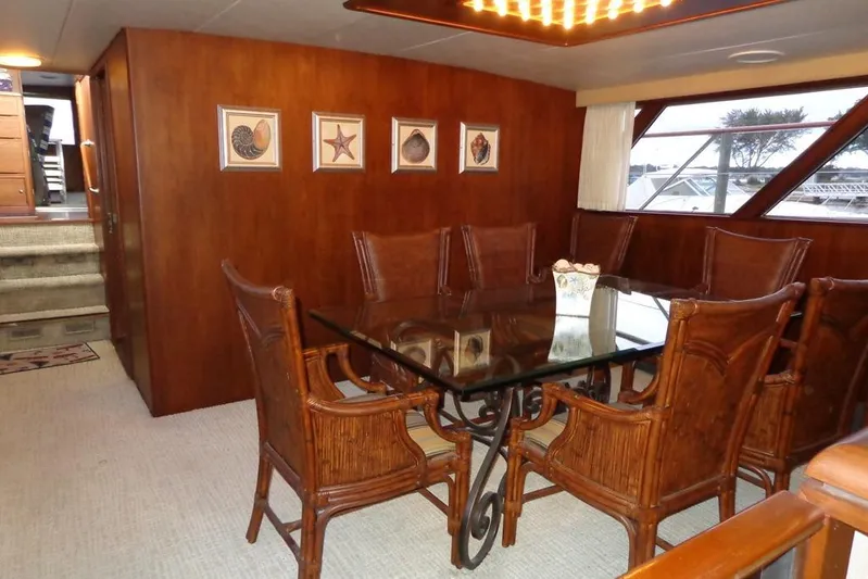  Yacht Photos Pics Luxurious dining area on 1988 Burger 80 Motor Yacht with glass table and wooden chairs.