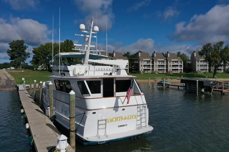  Yacht Photos Pics 1988 Burger 80 Motor Yacht docked at marina, surrounded by waterfront condos and lush greenery.