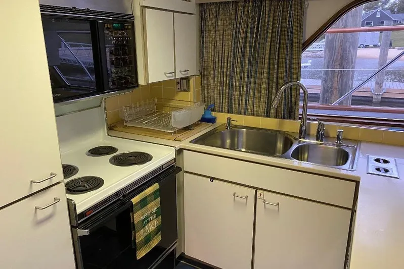  Yacht Photos Pics Kitchen area of a 1988 Burger 80 Motor Yacht with stove, sink, and window view.