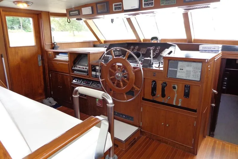  Yacht Photos Pics Interior helm of 1988 Burger 80 Motor Yacht with wooden steering wheel and navigation equipment.